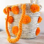 bolso cesta de doum con pompones anaranjados