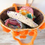 bolso cesta de doum con pompones anaranjados