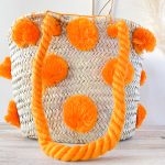 bolso cesta de doum con pompones anaranjados