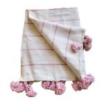 Manta blanca con lineas y pompones rosadas