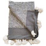 Manta gris y blanco de algodón con pompones blancos